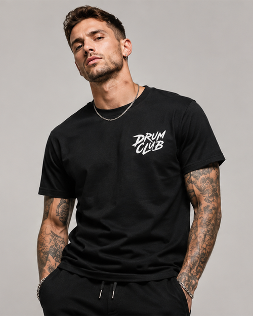 Man wearing a black t-shirt with 'DRUM CLUB' text on a gray background