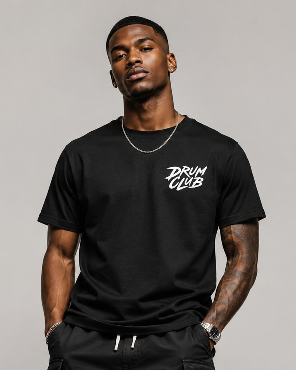 Man wearing a black t-shirt with 'DRUM CLUB' text on a gray background
